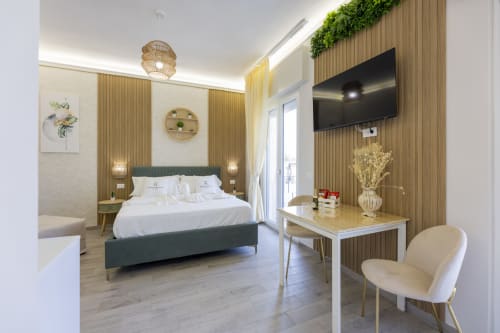 Elegante camera executive alle Aurum Nolana Suites di Pompei con letto king, balcone con vista montagna e TV a schermo piatto