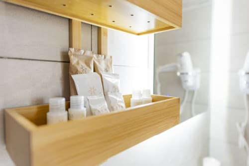 Scaffale in legno con articoli da toilette e prodotti omaggio presso l'Aurum Nolana Suites di Pompei