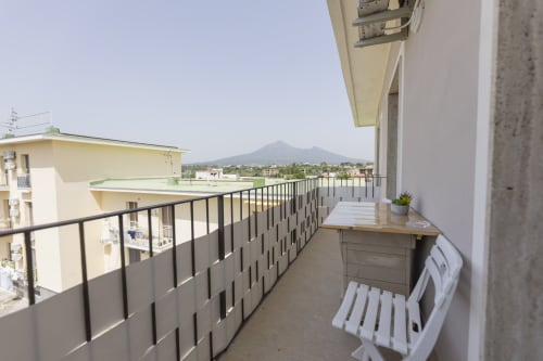 Balcone dell'Aurum Nolana Suites a Pompei con vista sulla montagna, sedute all'aperto e lettini