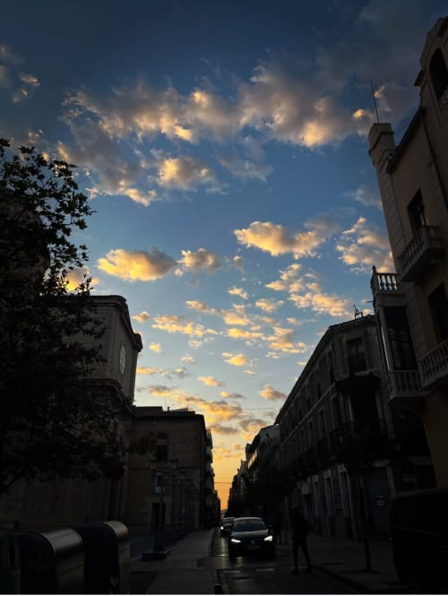 Sunset street view in Yecla town center with historic buildings and golden sky clouds