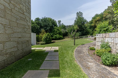 Villa de pedra com jardins cuidados, caminho de pedras e vistas para a montanha na Quinta Trindade em Arouca, Portugal