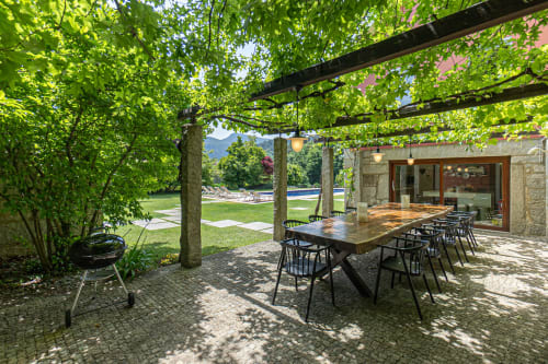 Terraço da quinta Trindade em Arouca com pérgola, mesa de refeições, churrasqueira e vistas de montanha