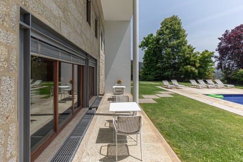 Terraço da villa moderna em Quinta Trindade em Arouca com zona de refeições, espreguiçadeiras, piscina e vistas para a serra