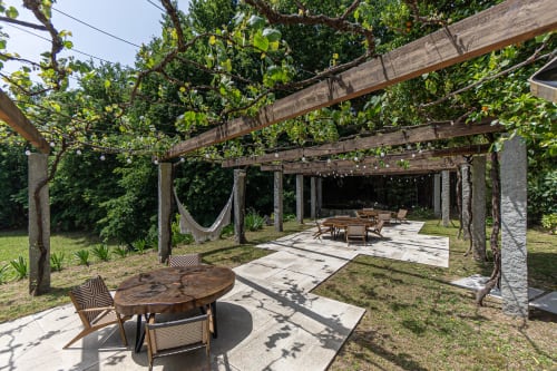 Zona de refeições e lounge ao ar livre com pérgula na Quinta Trindade em Arouca, rodeada de vegetação exuberante e vistas de montanha