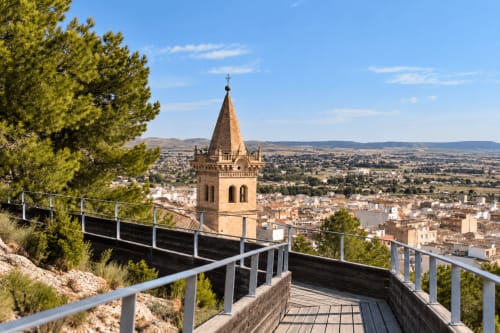 Yecla church tower viewed from wooden viewpoint with town landscape below, Spain