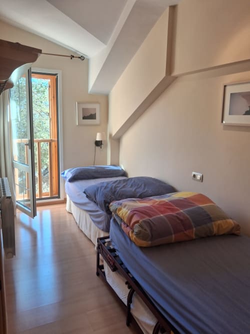 Dormitorio luminoso en cabaña invernal Casa Buenavista, Sierra Nevada, con dos camas, piso de madera y vistas a la montaña