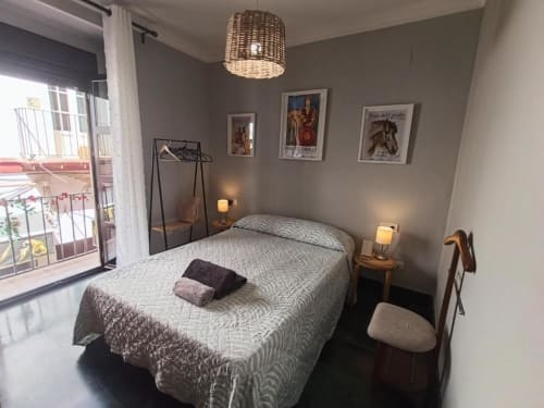 Dormitorio luminoso en apartamento Top Home Évora, Jerez de la Frontera, con cama queen, balcón con vistas a la ciudad y comodidades modernas