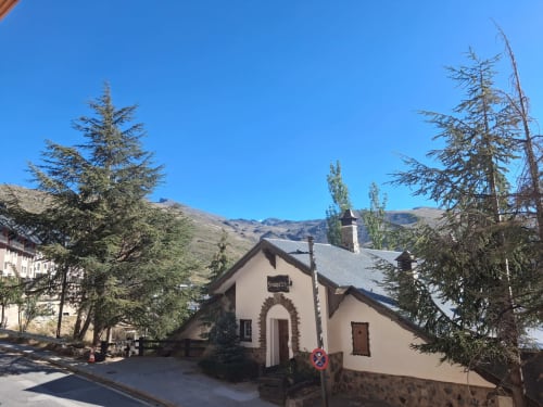 Casa Buenavista, cabaña invernal en Sierra Nevada Granada con vistas montañosas, rodeada de árboles alerce y arquitectura de piedra