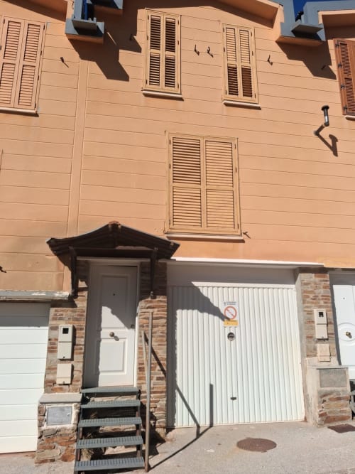 Fachada exterior de la casita Casa Buenavista en Sierra Nevada, Granada, con muros color durazno, persianas de madera y ladrillo