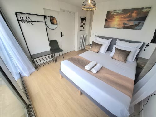 Chambre king-size moderne à La villa Cassinne B&B à Montebourg avec draps blancs, vue jardin et parquet