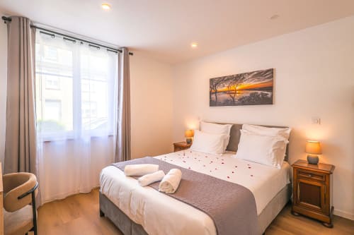 Chambre royale luxueuse à La villa Cassinne à Montebourg avec éclairage doux, vue sur jardin et équipements modernes