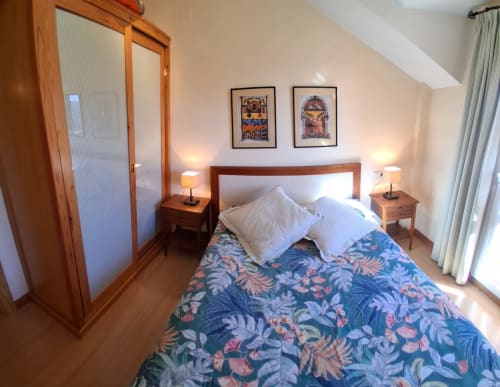 Acogedora habitación en la cabaña invernal Casa Buenavista en Sierra Nevada con ropa de cama floral, muebles de madera y vistas a las montañas