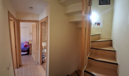 Pasillo invernal de Casa Buenavista con escaleras de madera y puertas en cabaña de Sierra Nevada