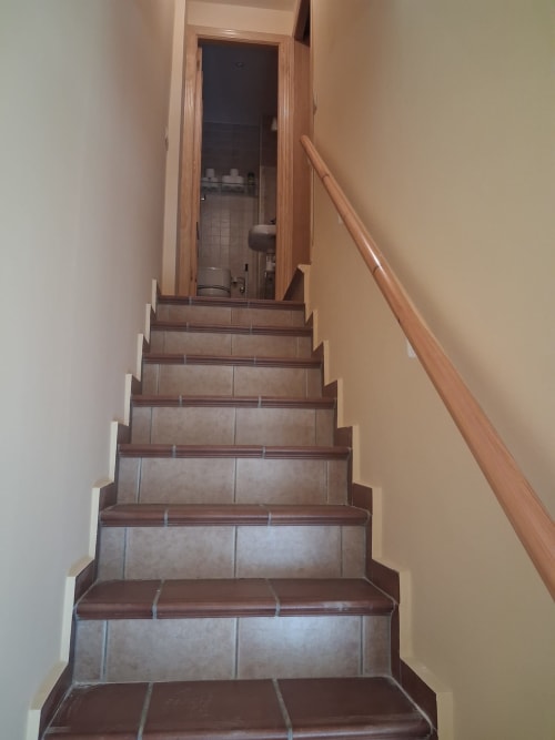 Escalera con azulejos y barandilla de madera en Casa Buenavista, cabaña invernal en Sierra Nevada