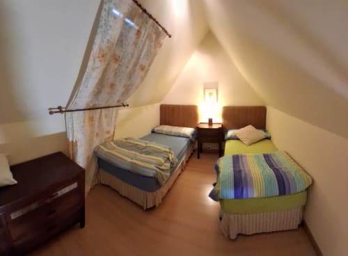 Acogedora habitación en buhardilla de Casa Buenavista Winter en Sierra Nevada con dos camas individuales, muebles de madera y vistas a las montañas