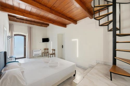 Bright MARII Triple Room at Sikania Agri Relais in Caccamo with wooden beams, spiral staircase, and mountain views
