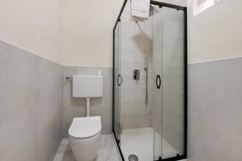 Modern bathroom at Sikania Agri Relais in Caccamo with shower enclosure, toilet, and white towels