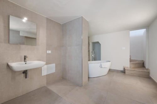 Modern bathroom in Sikania Agri Relais apartment with sink, walk-in shower, and freestanding tub in Caccamo, Sicily