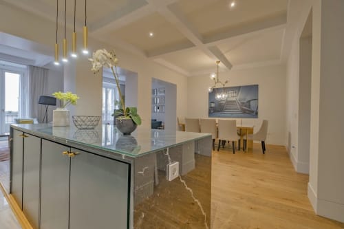 Cocina y comedor de apartamento moderno en Madrid con isla de mármol, iluminación colgante y muebles elegantes en Andimi