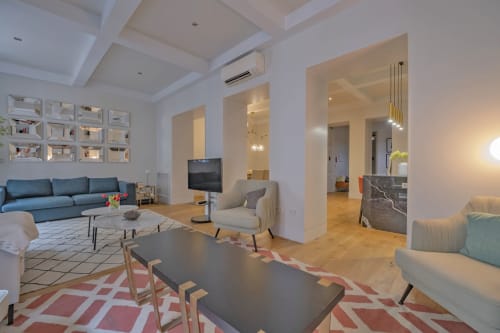 Moderno salón de apartamento en Madrid con sofá azul, zona de comedor y distribución abierta en Andimi Apartaments
