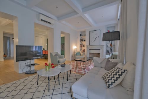 Acogedora sala de estar de apartamento moderno en Madrid con cómodos asientos, chimenea, TV de pantalla plana y elegante decoración en Andimi
