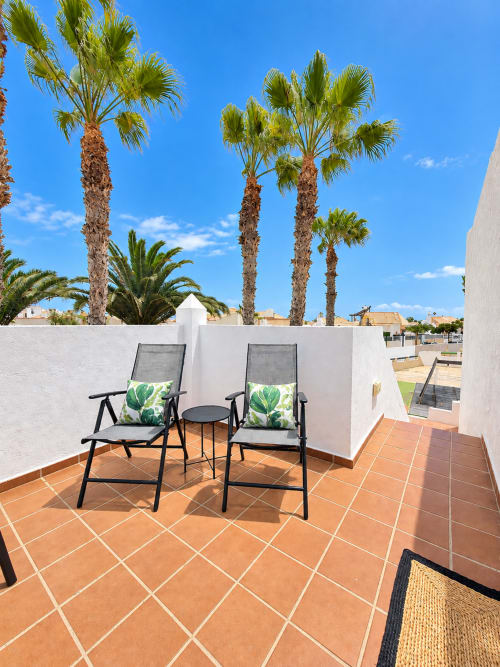 Dachterrasse mit Liegestühlen, Palmen und weißer Architektur im Sara & Gino Fuerteventura in Corralejo