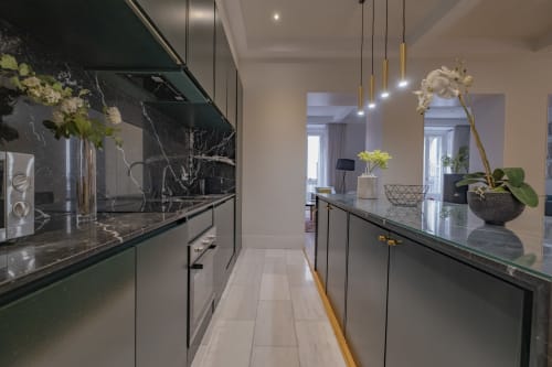 Cocina de lujo moderna en apartamento madrileño con encimeras de mármol, lámparas colgantes y vistas a la ciudad