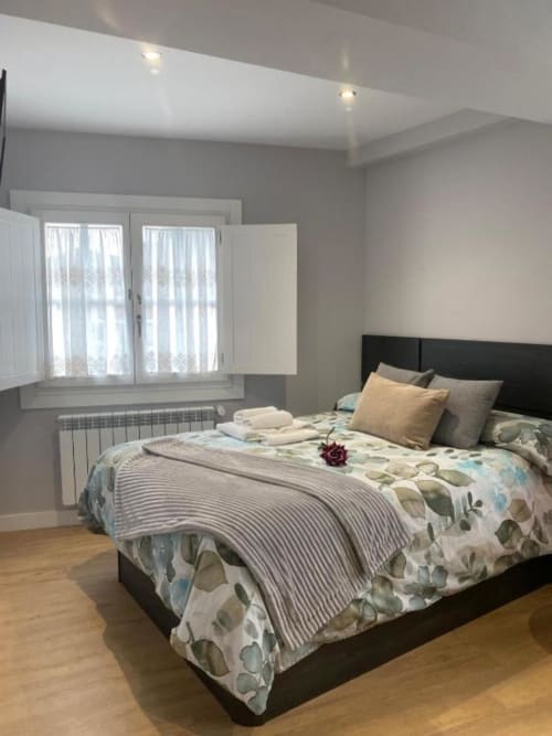 Amplia habitación doble en hotel A Casiña D'Avoa en Osera con mobiliario moderno, ropa de cama floral y luz natural