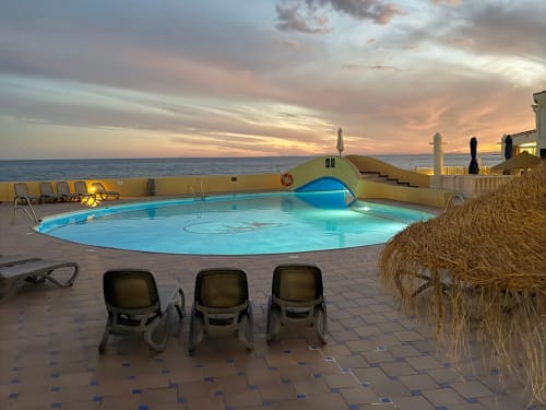 Beachfront pool at sunset with loungers overlooking the Mediterranean Sea at HomyMarbella, Calahonda