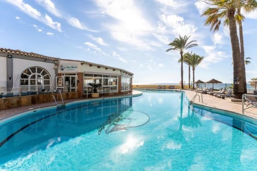 Curved swimming pool with sea view at HomyMarbella beachfront resort in Calahonda, Spain with palm trees and poolside