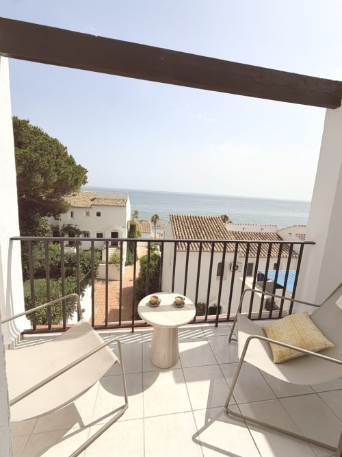 Seaview balcony at HomyMarbella Calahonda cottage with lounge chairs, table, and Mediterranean sea views