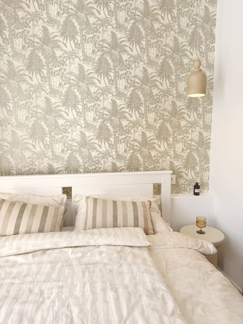 Coastal bedroom at HomyMarbella Seaview Townhouse with tropical wallpaper, striped pillows, and pendant lighting