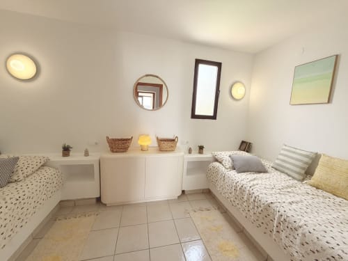 Modern twin bedroom at HomyMarbella cottage with white furnishings, coastal decor, and tile flooring