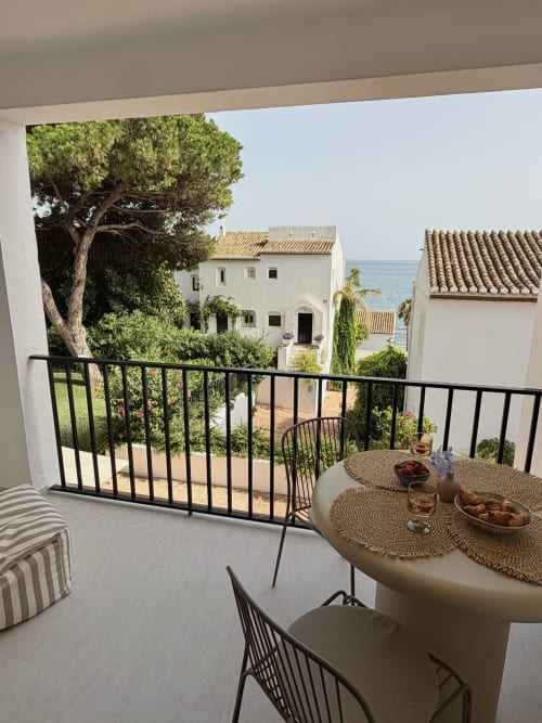 Balcony terrace with dining table overlooking Mediterranean sea and white townhouses in Calahonda, Marbella
