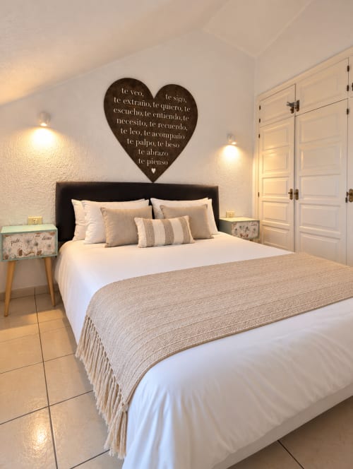 Modern bedroom at Manage Home Tenerife with queen bed, black headboard, decorative heart wall art, and white built-in