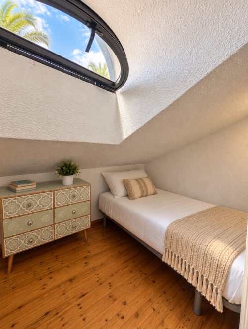 Bright attic bedroom with skylight, wooden floor, and modern furnishings at Manage Home Tenerife apartment