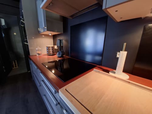 Cuisine moderne du gîte Love Room Sensation, Esches, avec plan de travail rouge, cuisinière à induction et crédence sombre