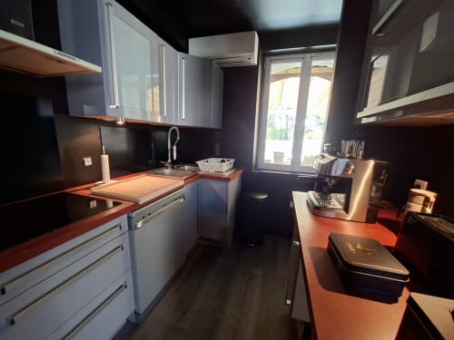 Cuisine moderne du gîte Love Room Sensation à Esches, avec placards blancs, plan de travail rouge et dosseret noir