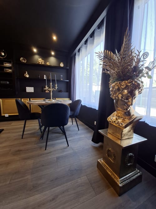 Élégante salle à manger avec buste doré, chaises noires et baies vitrées à l'hôtel Love Room Sensation