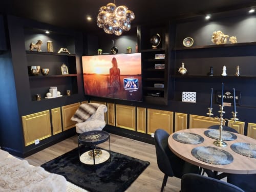 Chambre romantique luxueuse avec murs bleu marine, finitions dorées, TV écran plat, élégante salle à manger et mobilier contemporain