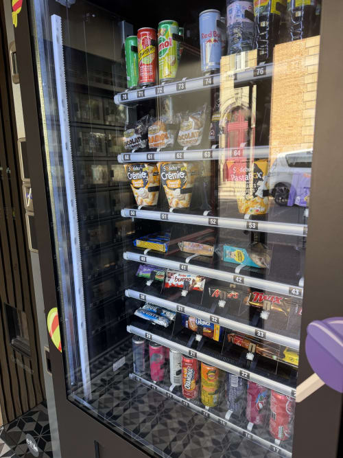 Distributeur automatique à l'hôtel Le Celtic du Thillay proposant boissons, snacks et confiseries