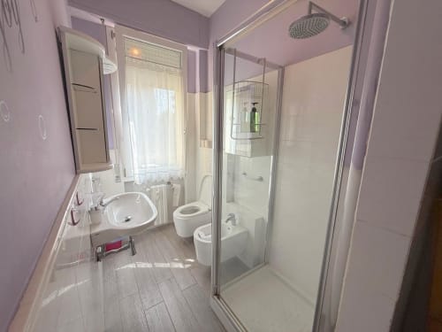 Moderno bagno nell'appartamento Deledda a Firenze, con doccia walk-in, WC, lavabo e scaldasalviette