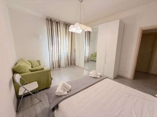 Camera da letto spaziosa dell'appartamento Florence Sweet Homes a Scandicci con armadio specchiato, zona living verde e vista sulla città