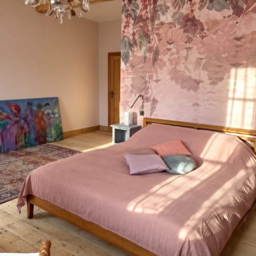 Chambre à la Maison Crone B&B à Castillon-en-Couserans avec lit rose, papier peint fleuri et vue sur jardin