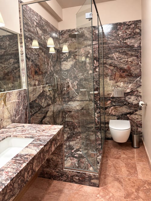 Salle de bain luxueuse à la Maison Crone avec murs en marbre, douche vitrée et équipements modernes à Castillon-en-Couserans