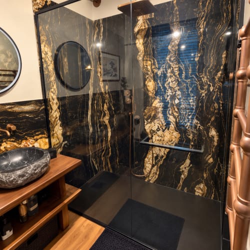 Salle de bains luxueuse de la Maison Crone B&B avec douche en marbre noir et or et meuble vasque en bois, Castillon-en-Couserans