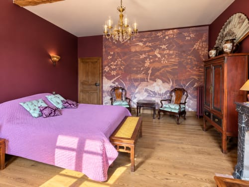 Chambre élégante à la Maison Crone B&B à Castillon-en-Couserans avec literie rose, murs bordeaux et fresque inspirée d'Asie