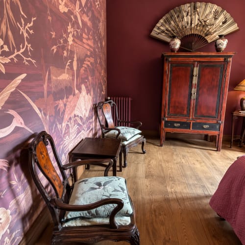 La Chambre des Hirondelles de Maison Crone à Castillon-en-Couserans présente des murs bordeaux, des panneaux laqués ornementés et
