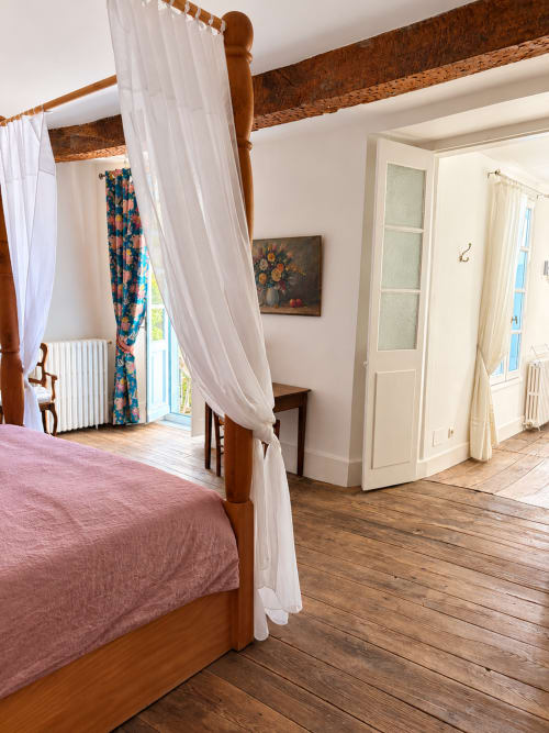 Chambre spacieuse avec lit à baldaquin en bois et voilages blancs à la Maison Crone, Castillon-en-Couserans