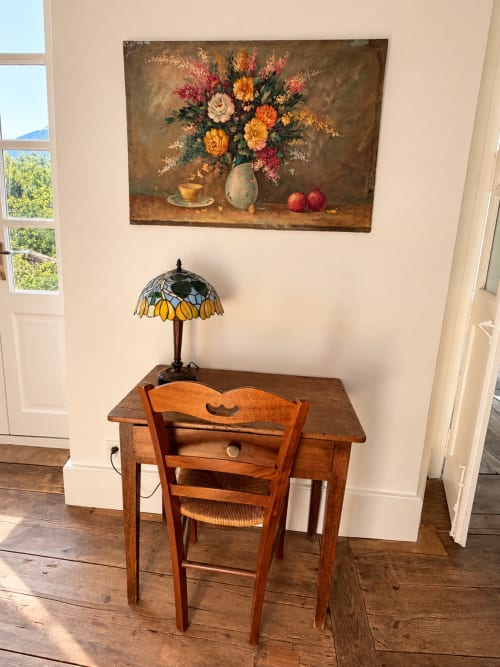 Bureau en bois avec lampe Tiffany dans la Chambre Eva à la Maison Crone, Castillon-en-Couserans, décoration florale au-dessus